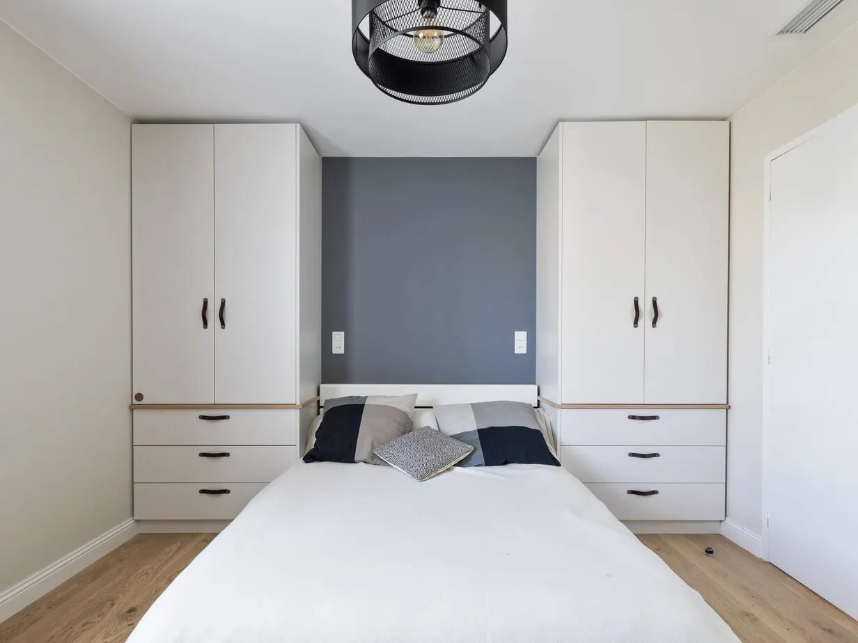 Chambre parentale peinte à Carmaux : mur d'accent gris-bleu derrière le lit, placards blancs et parquet clair - Brice Molluna